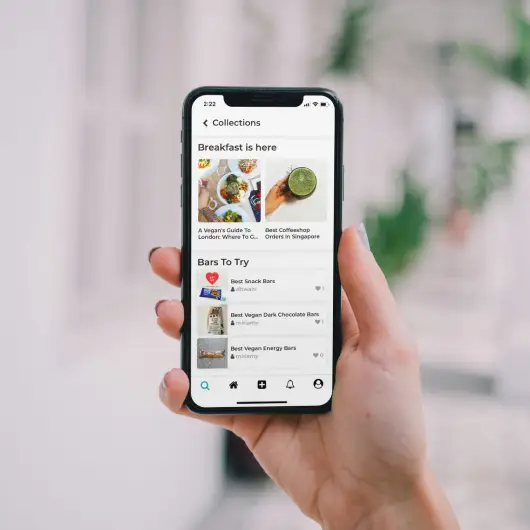 a feamle hand holding a smartphone with a food shopping app on the screen